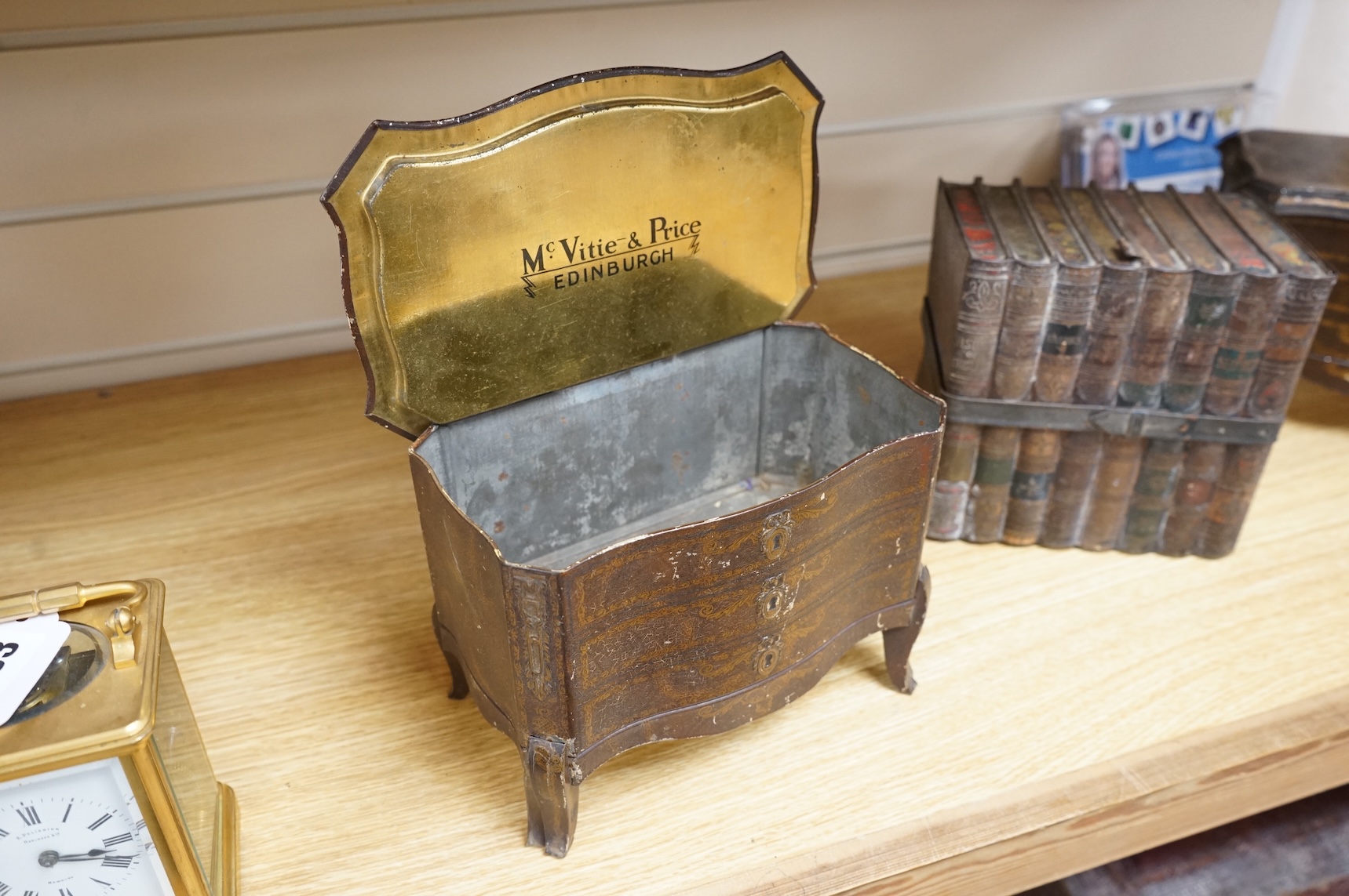 A Huntley and Palmer biscuit tin, modelled as a set of books and and two Mcvitie and Price tins modelled as French chests, tallest 16cm
